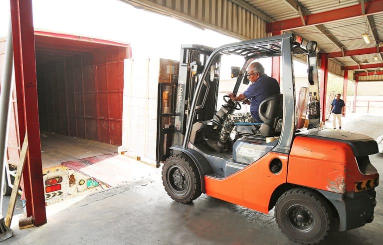 Forklift loading a pallet onto a box truck at Al Talib warehouse