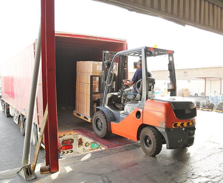 Forklift loading cargo in a container truck from Al Talib Shipping Company
