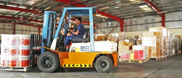 Forklift placing pallet of paint boxes in Al Talib warehouse, Dubai