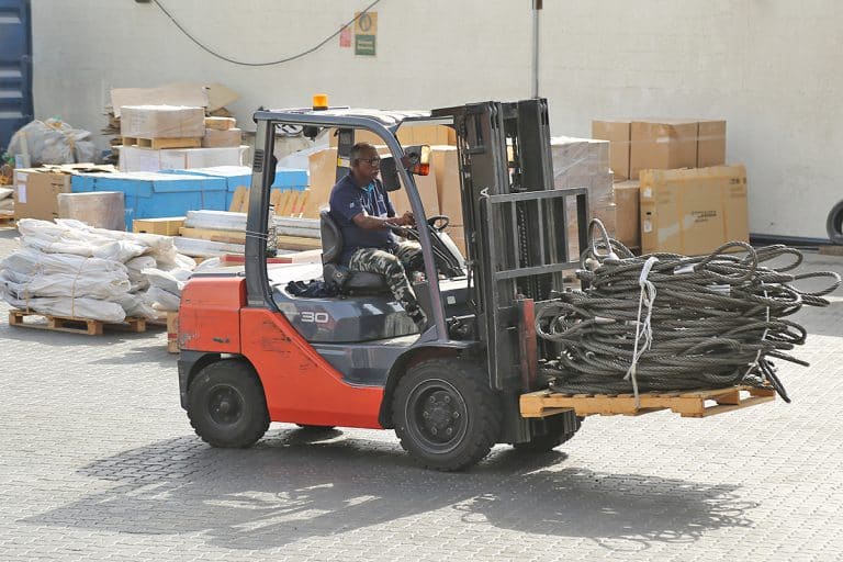 Forklift shifting industrial cargo at Al Talib Shipping Company warehouse dubai