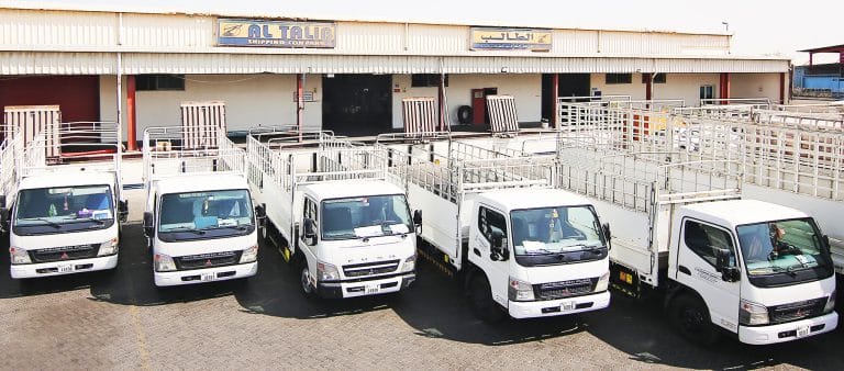 Al Talib Shipping Company cargo trucks outside warehouse